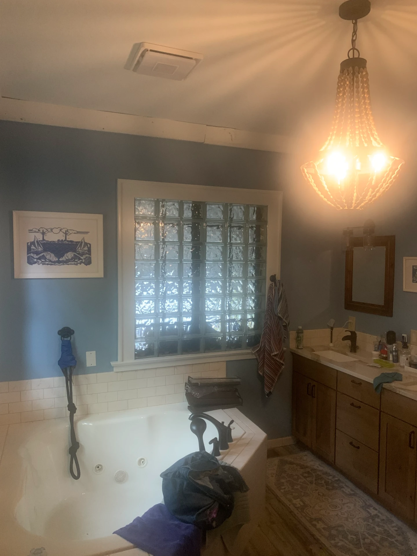 Bathroom with blue gray painted walls and white trim around a glass block window