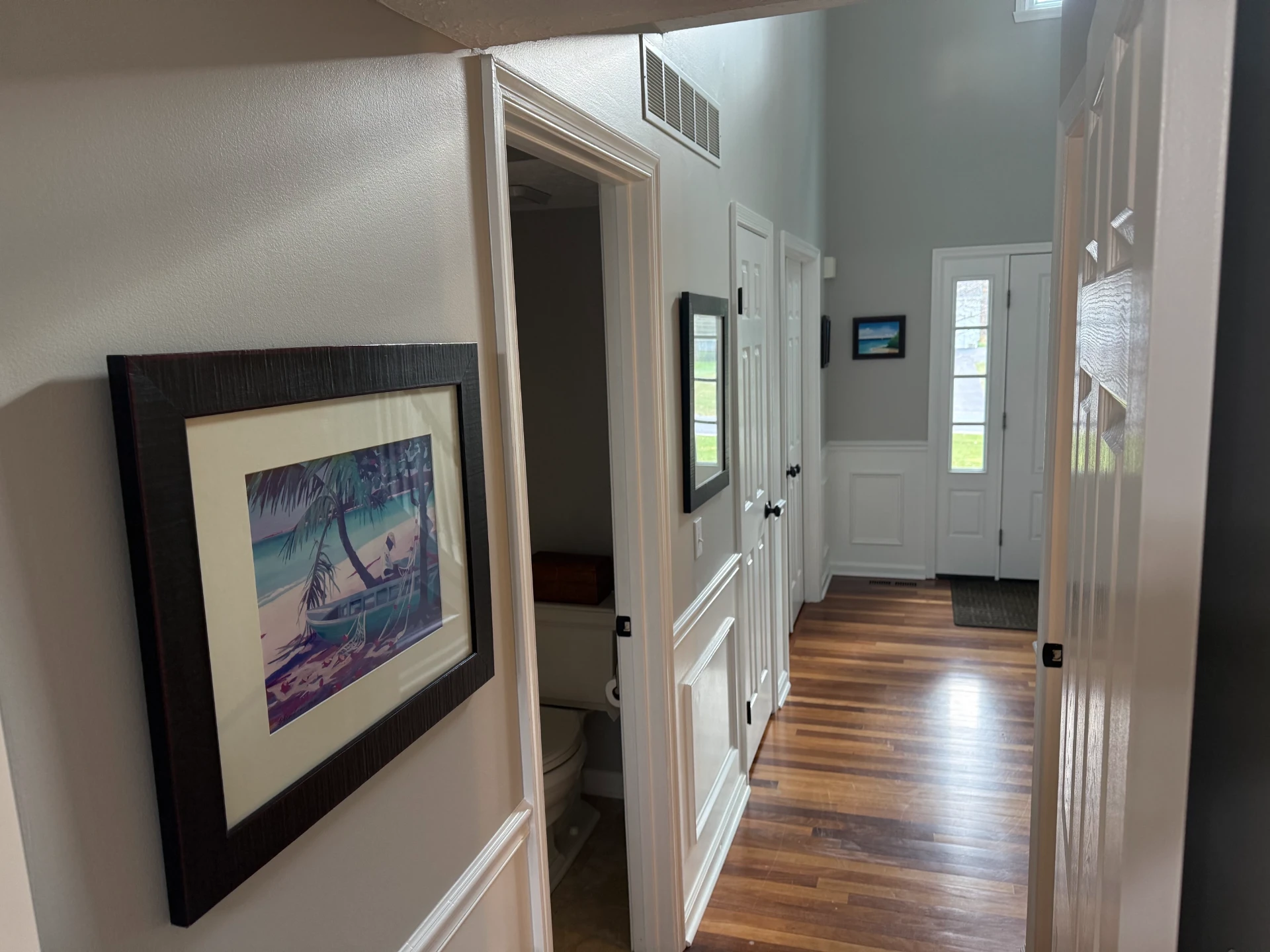 Hallway with crisp white shadow box wainscoting and gray upper walls